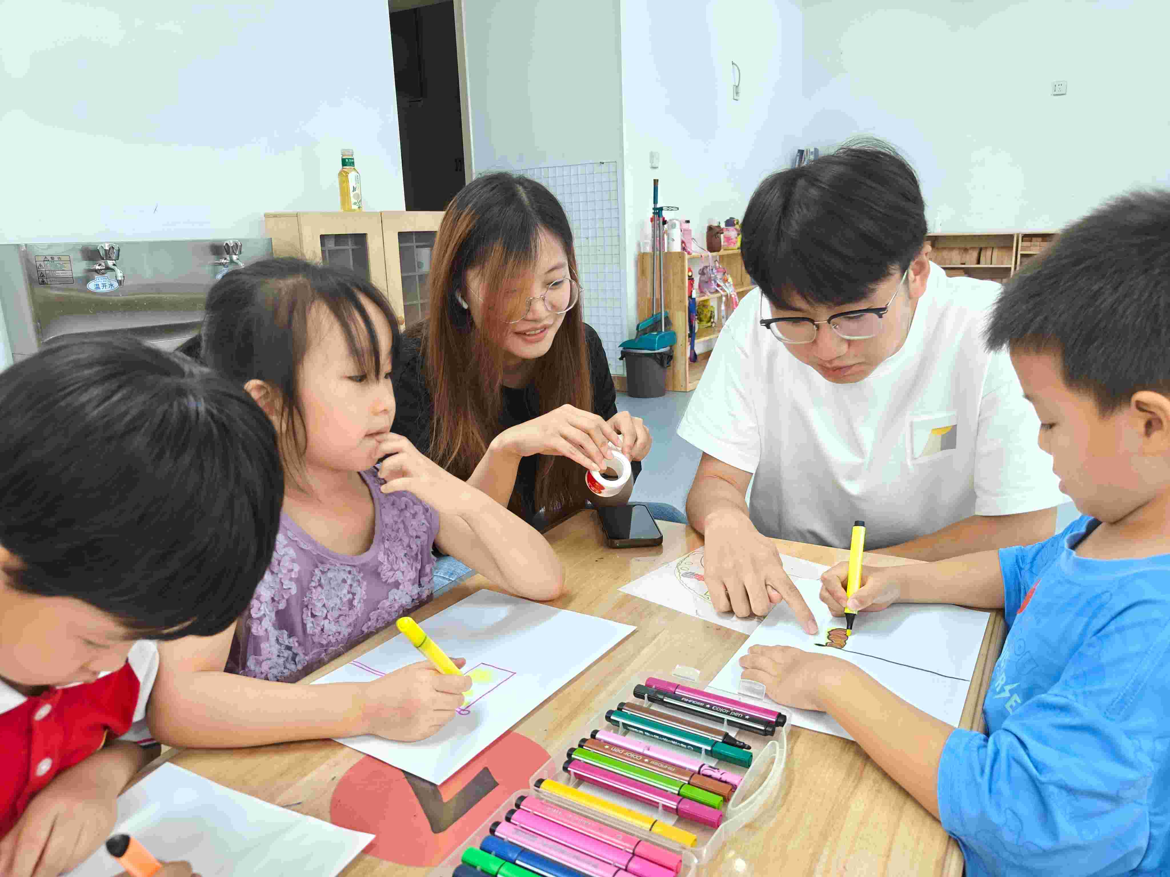 圖為實(shí)踐團(tuán)成員宋立豪、譚依然在協(xié)助小朋友們完成畫作
